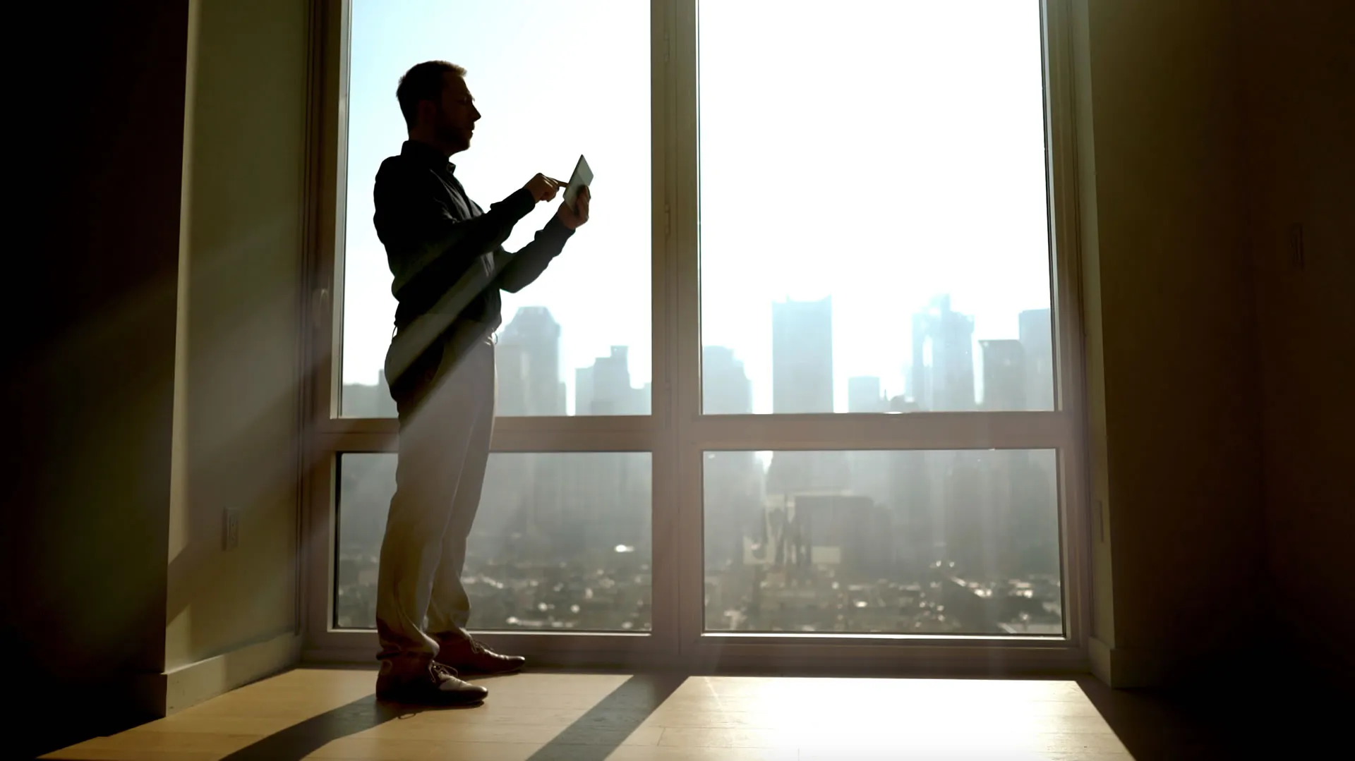 Pessoa contemplando o skyline da cidade ao amanhecer, símbolo de sucesso e patrimônio